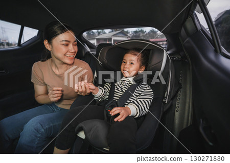 happy mother take care her toddler girl in car seat. play and talking with child happy mother take care her toddler girl in car seat. play and talking with child 130271880