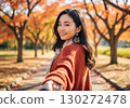A woman wearing a brown knit and scarf on a date, holding hands 130272478