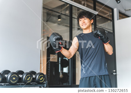 健身房，亞洲年輕男子在訓練館進行拳擊練習 130272655