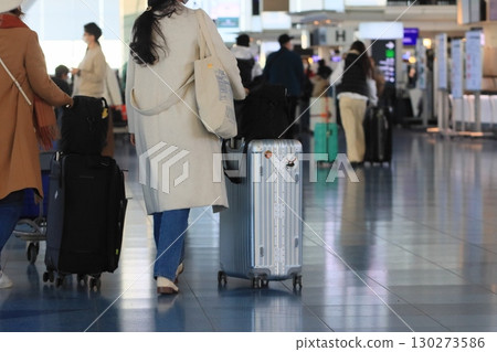 Travelers pulling suitcases, Haneda Airport departure lobby, travelers Travelers pulling suitcases, Haneda Airport departure lobby, travelers 130273586