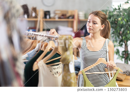 Girl customer choose tank top in store 130273803