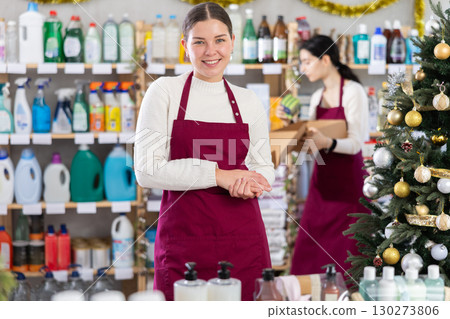 Young saleswoman welcoming clients while other working in background Young saleswoman welcoming clients while other working in background 130273806