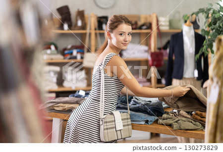 Woman shopping in clothing department, buying denim pantalones 130273829