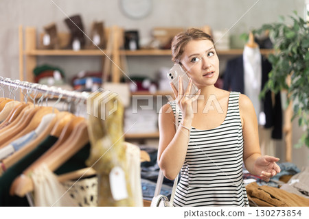 Woman making a phone call in a store Woman making a phone call in a store 130273854