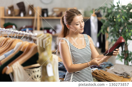 Young beautiful girl chooses fashionable shoes in prestigious store 130273857