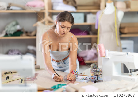 Young fashion designer drawing patterns on paper 130273968