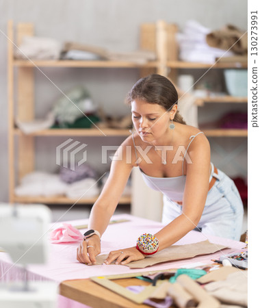 Woman dressmaker making markings on textiles Woman dressmaker making markings on textiles 130273991