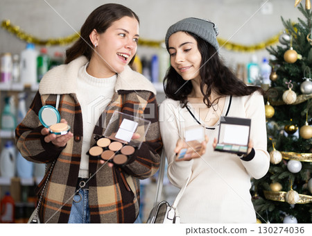 Women friends choose cosmetics in decorated store 130274036