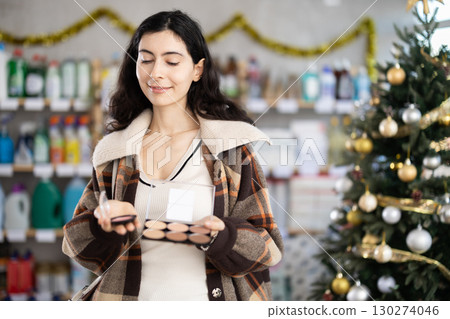 Young girl choosing cosmetics in retail store with New Year decoration 130274046