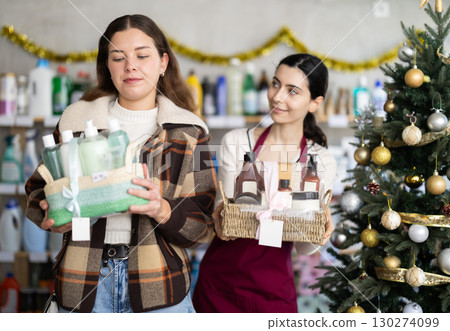 Woman seller offers cosmetics gift sets for christmas to woman buyer Woman seller offers cosmetics gift sets for christmas to woman buyer 130274099