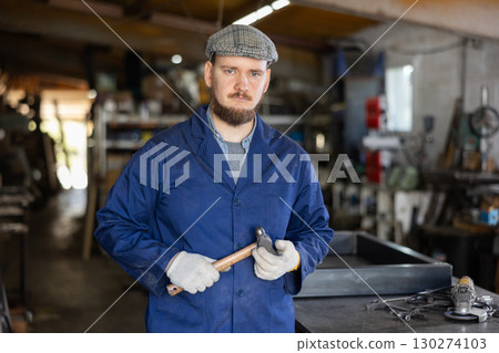 Young male worker posing in workshop Young male worker posing in workshop 130274103