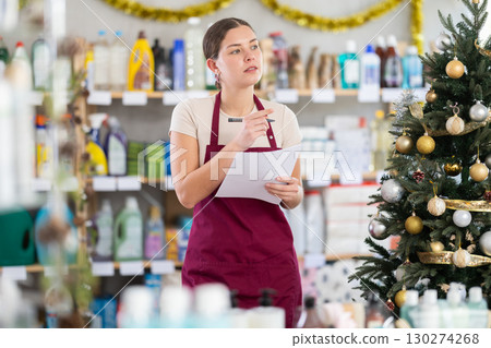 Female salesperson filling out documents in supermarket Female salesperson filling out documents in supermarket 130274268