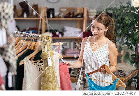 woman chooses clothes from the summer collection woman chooses clothes from the summer collection 130274407