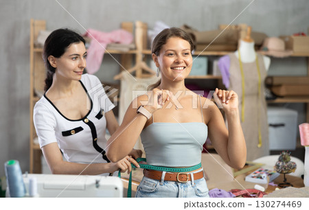 dressmaker takes measurements from the client dressmaker takes measurements from the client 130274469