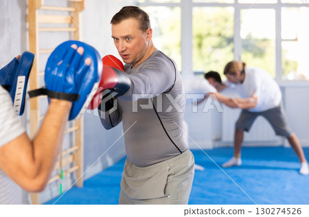 Two men training boxing fight in studio Two men training boxing fight in studio 130274526