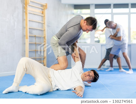 Two men training judo technique in studio Two men training judo technique in studio 130274561