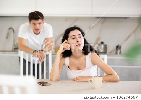 Young guy quarrels with young woman in kitchen 130274567