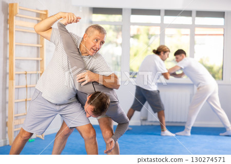 Adult and elderly men training judo fight Adult and elderly men training judo fight 130274571