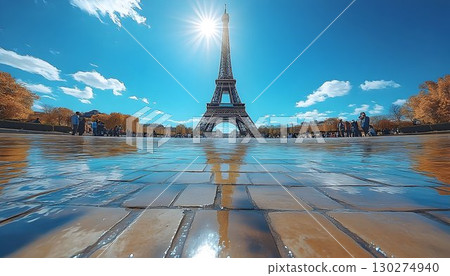 Eiffel Tower Shimmers: Sunburst and Reflections on Wet Pavement Eiffel Tower Shimmers: Sunburst and Reflections on Wet Pavement 130274940