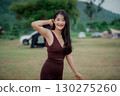 Beautiful Asian woman wearing sexy dress, smiling happily on vacation. 130275260