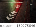 A rain-soaked bicycle lane illuminated by a red light 130275646