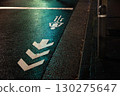 A rain-soaked bicycle lane illuminated by a green light 130275647
