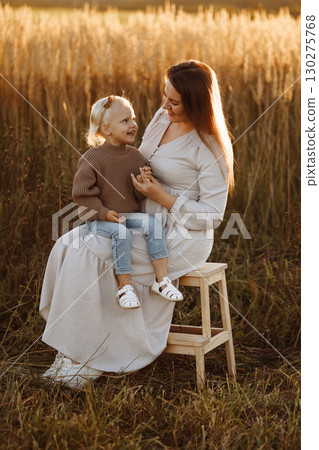 Mother and Daughter Smiling in Wheat Field at Sunset 130275768