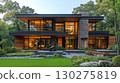 Modern two story house with a sleek design, illuminated exterior, and landscaped front yard  with patio 130275819