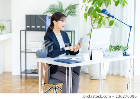 Business woman with a smartphone Business woman with a smartphone 130276396