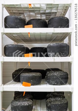 Aging Black Cheese Heads on Shelves in Storage Room Culinary Delights Awaiting Consumption Aging Black Cheese Heads on Shelves in Storage Room Culinary Delights Awaiting Consumption 130276518