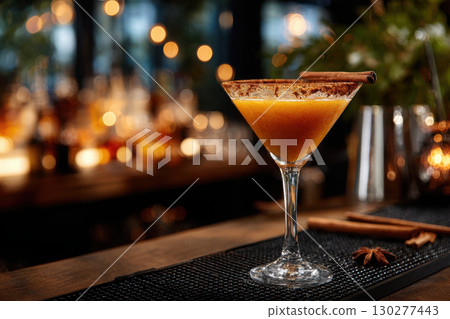Rich amber cocktail served in a martini glass at a cozy bar Rich amber cocktail served in a martini glass at a cozy bar 130277443