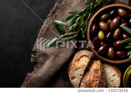 Overhead view of olives, olive oil, and fresh bread on linen 130278248