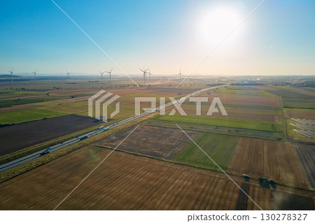Trucks and cars on highway with wind turbines in background 130278327
