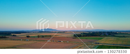 Scenic countryside with highway among fields and mountains at sunset Scenic countryside with highway among fields and mountains at sunset 130278330