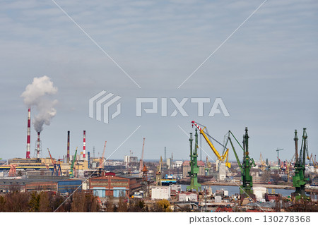 Port cranes and shipyard in industrial harbor city. 130278368
