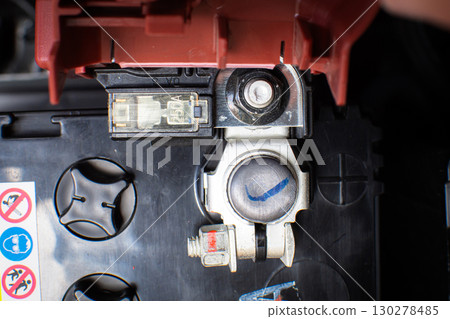 Close-up of a car battery positive terminal in red with fuse and connector Close-up of a car battery positive terminal in red with fuse and connector 130278485
