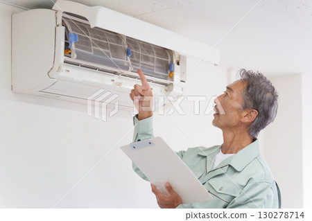 Senior male repairman checking air conditioner Senior male repairman checking air conditioner 130278714