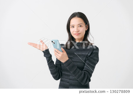 A woman giving directions while looking at her smartphone A woman giving directions while looking at her smartphone 130278809