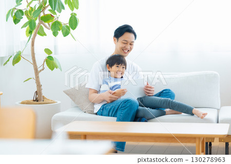 Family tablet dad and son relaxing on sofa Family tablet dad and son relaxing on sofa 130278963