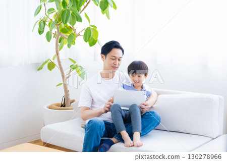 Family tablet dad and son relaxing on sofa Family tablet dad and son relaxing on sofa 130278966