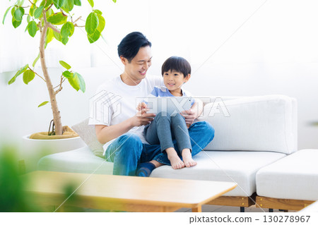 Family tablet dad and son relaxing on sofa Family tablet dad and son relaxing on sofa 130278967