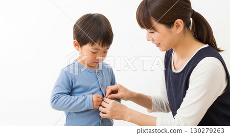 A mother buttoning her child's clothes 130279263