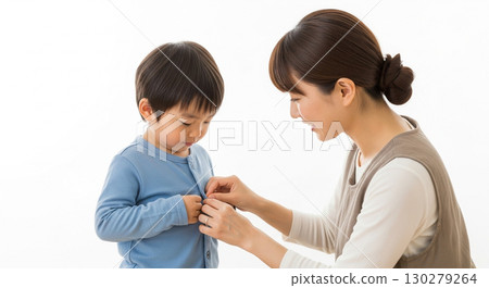 A mother buttoning her child's clothes 130279264