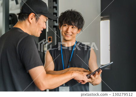 A male trainer giving individual instruction to members at a personal gym A male trainer giving individual instruction to members at a personal gym 130279512