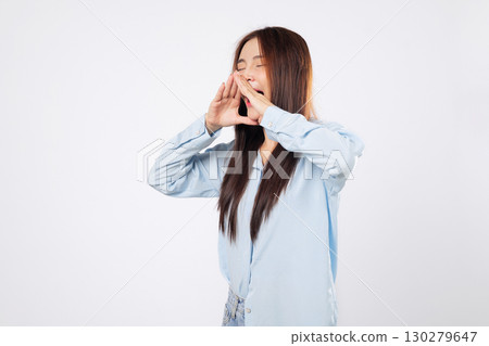 Mouth open wide, shouting woman gives advice, while another woman shares exciting news quietly with cupped hands, standing against a white studio isolated background. 130279647