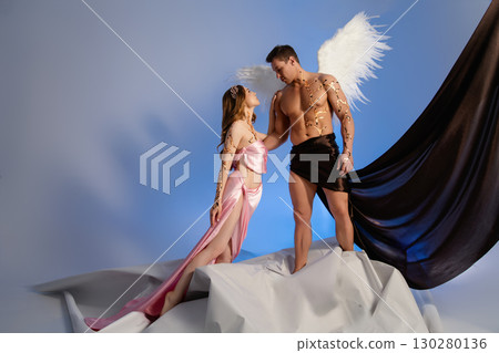 Romantic fantasy photoshoot featuring a couple with creative costumes and wings 130280136