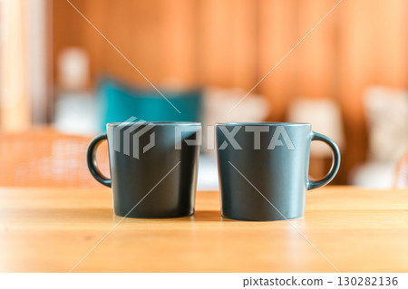 A pair of mugs and coffee cups on the table 130282136