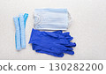 Medical face masks, hats and gloves laying on table flat lay view with copy-space 130282200
