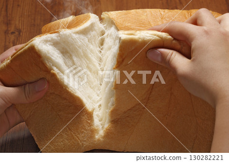 Breaking a square loaf of bread by hand (close-up) Breaking a square loaf of bread by hand (close-up) 130282221