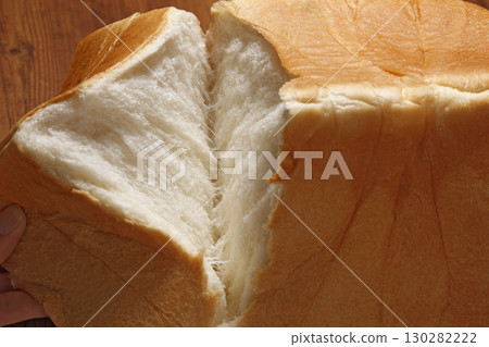 Breaking a square loaf of bread by hand (close-up) Breaking a square loaf of bread by hand (close-up) 130282222